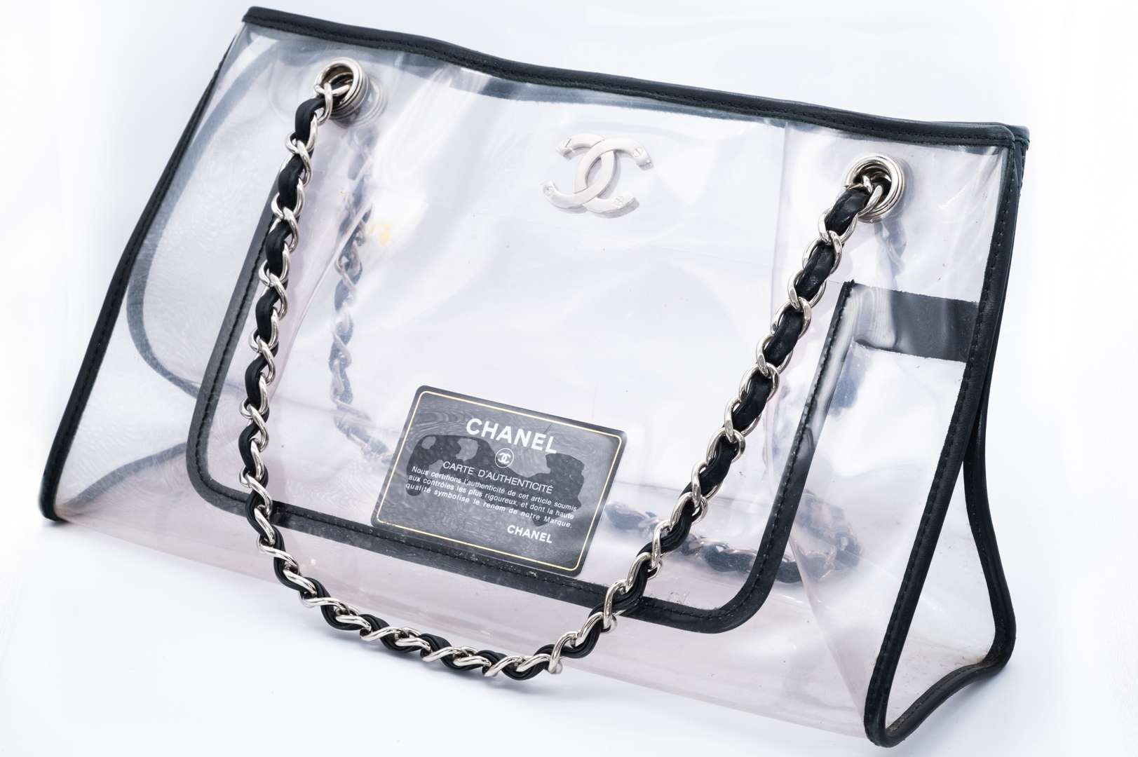 <p>CHANEL, PVC tote bag, with black leather trim and silver curb link chain carry strap. 2006-2008</p>