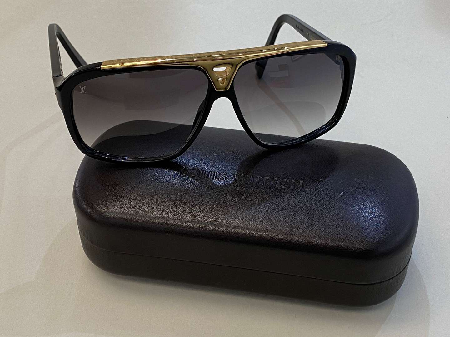 <p>LOUIS VUITTON, a pair of Italian, gilt mounted, black framed sunglasses</p>