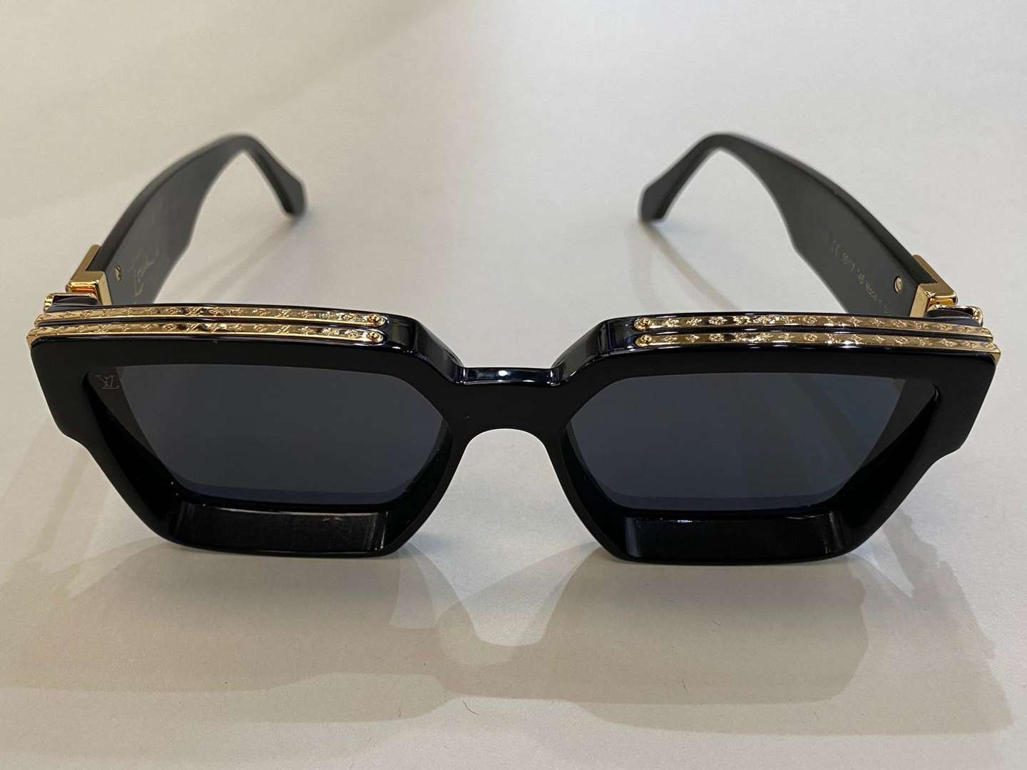 <p>LOUIS VUITTON, a pair of Italian gilt highlighted, black framed sunglasses</p>