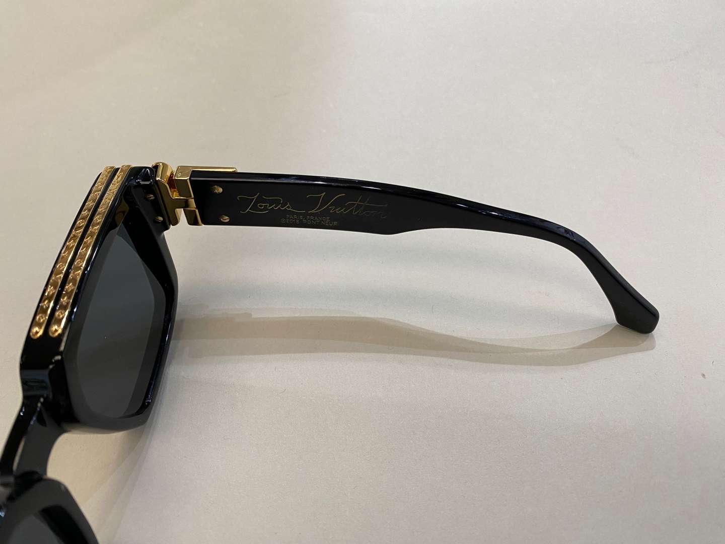 <p>LOUIS VUITTON, a pair of Italian gilt highlighted, black framed sunglasses</p>