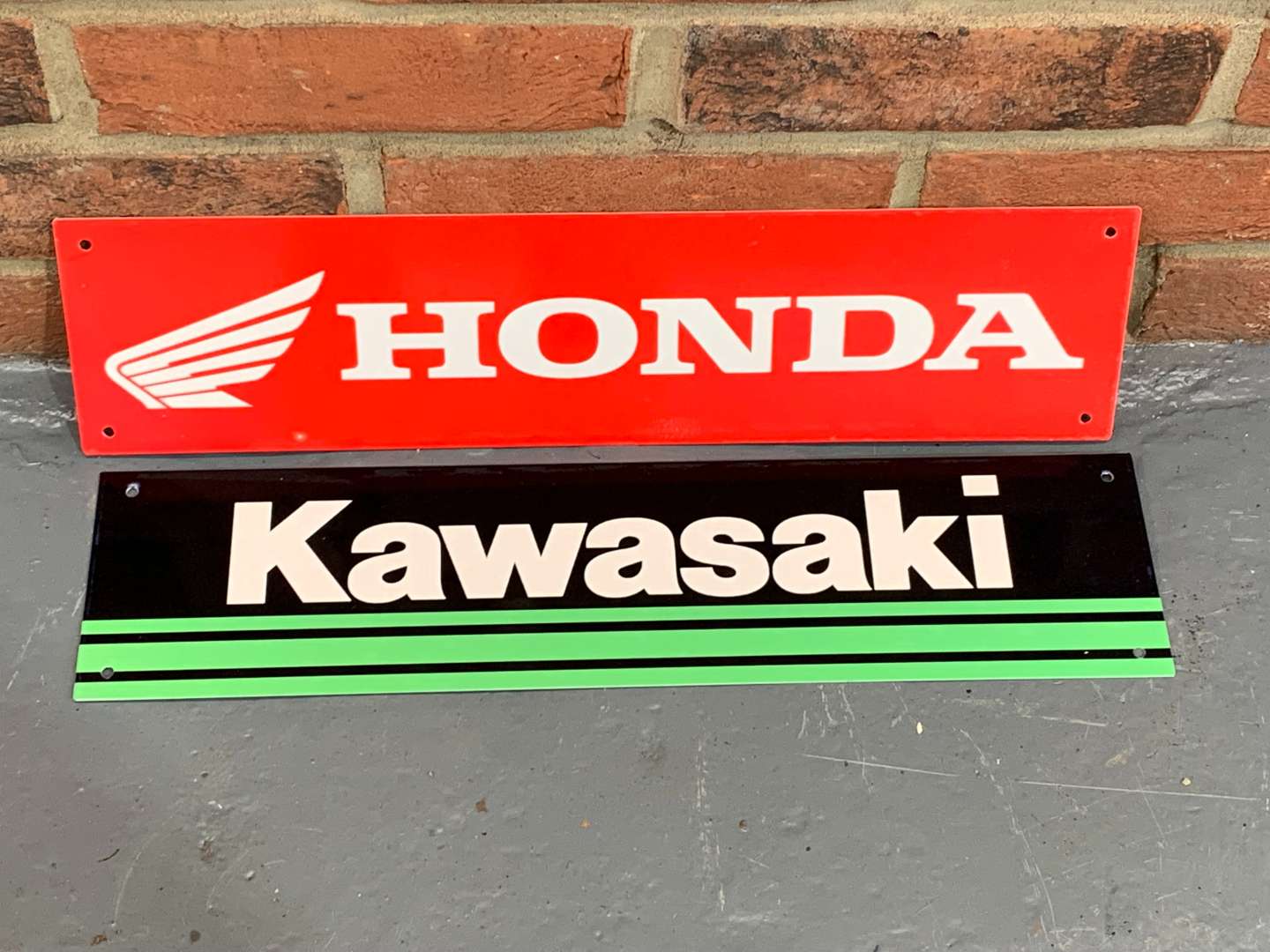 <p>Two Metal Honda and Kawasaki Signs</p>