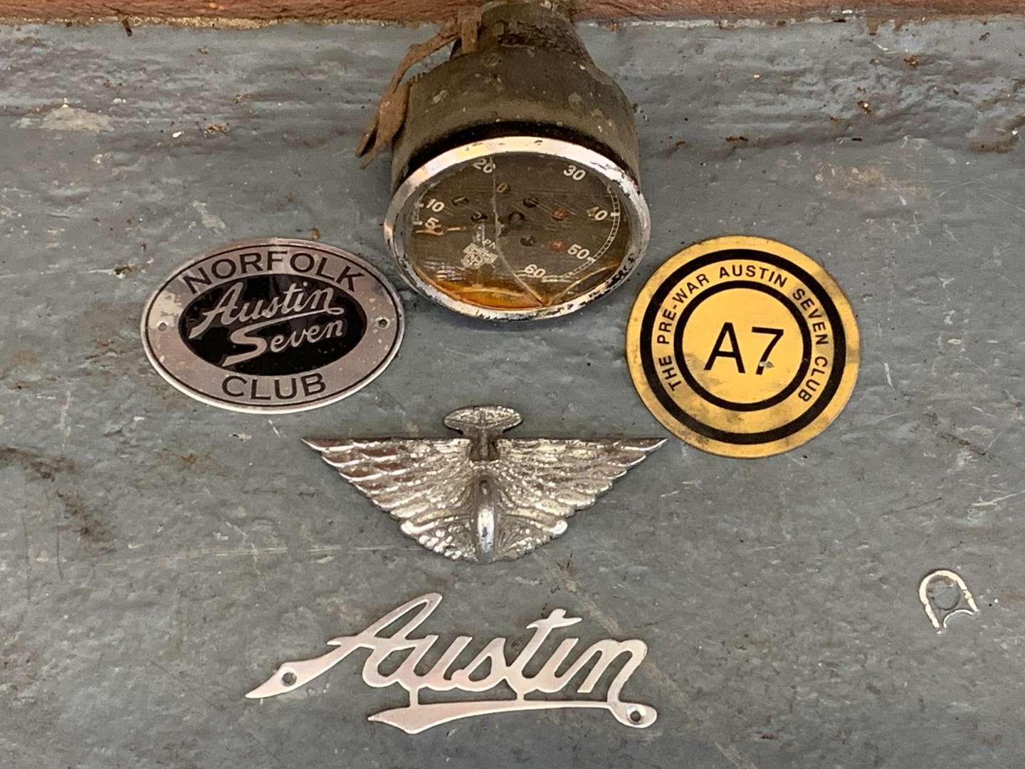 <p>Four Austin Car Badges and Early Smith Speedometer&nbsp;</p>