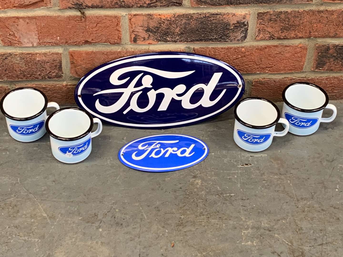 <p>Four Modern Ford Enamel Mugs and Two Badges</p>