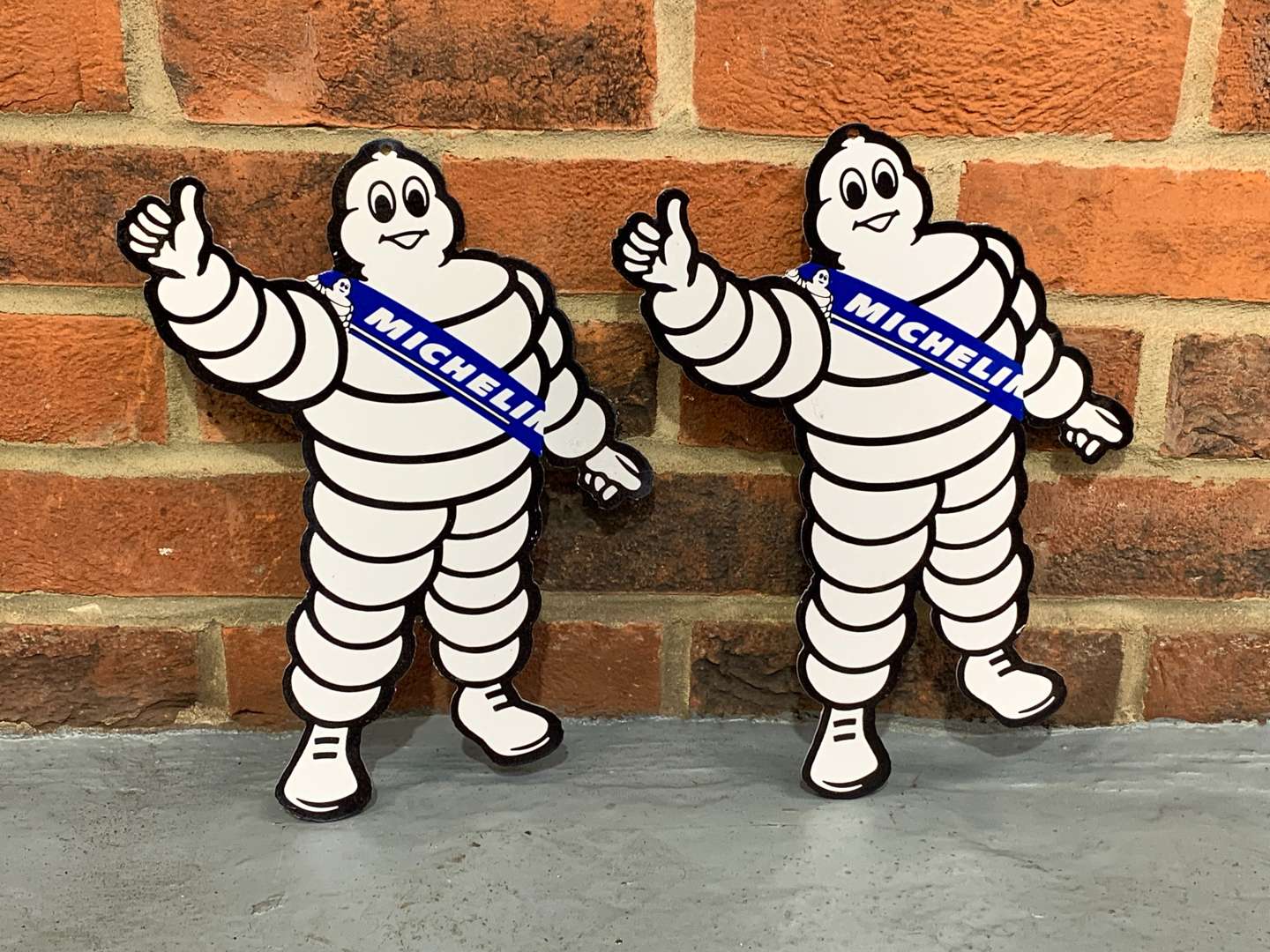 <p>Pair of Metal Small Michelin Men Signs</p>