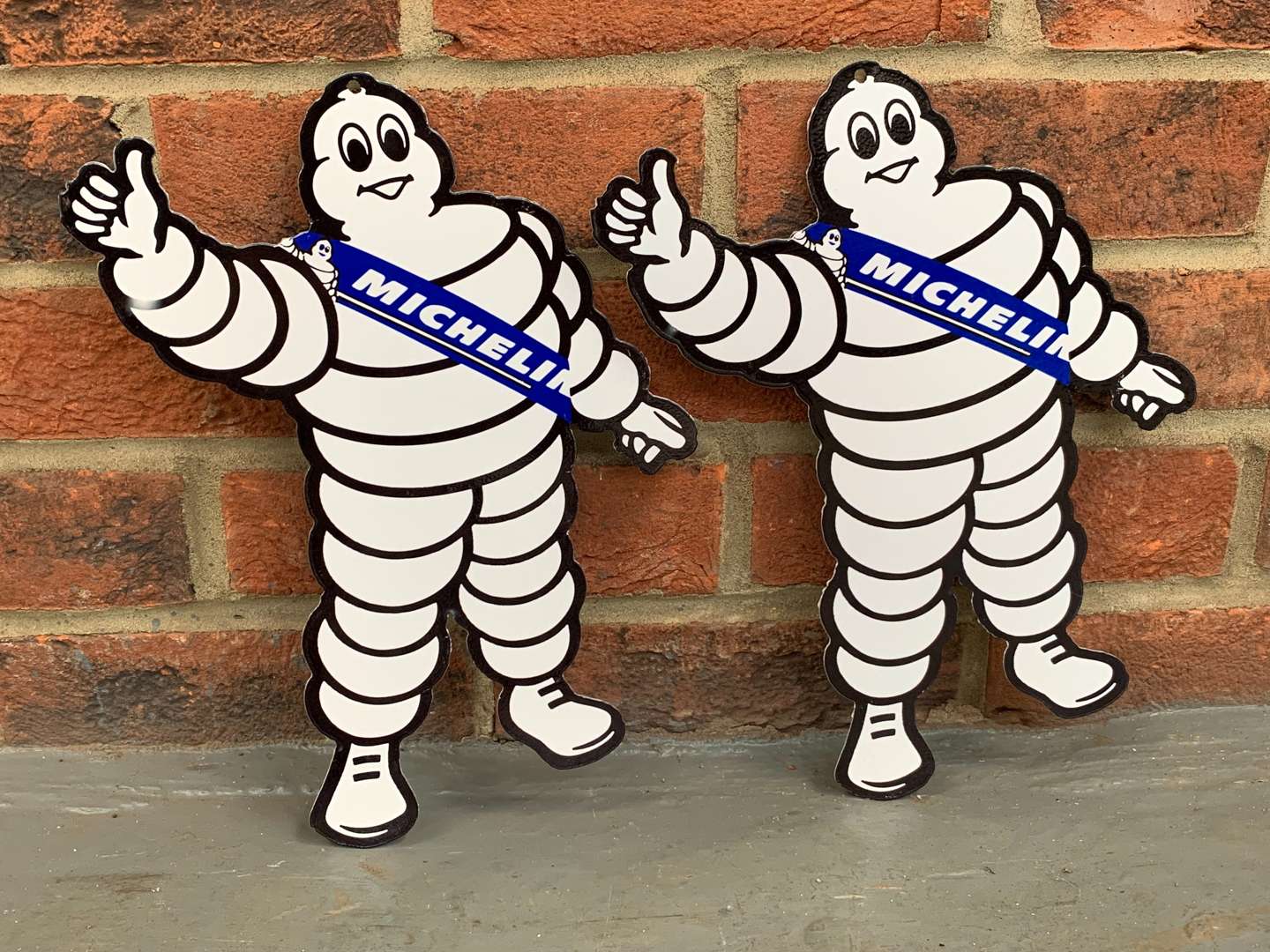 <p>Two Metal Small Michelin Men Signs</p>