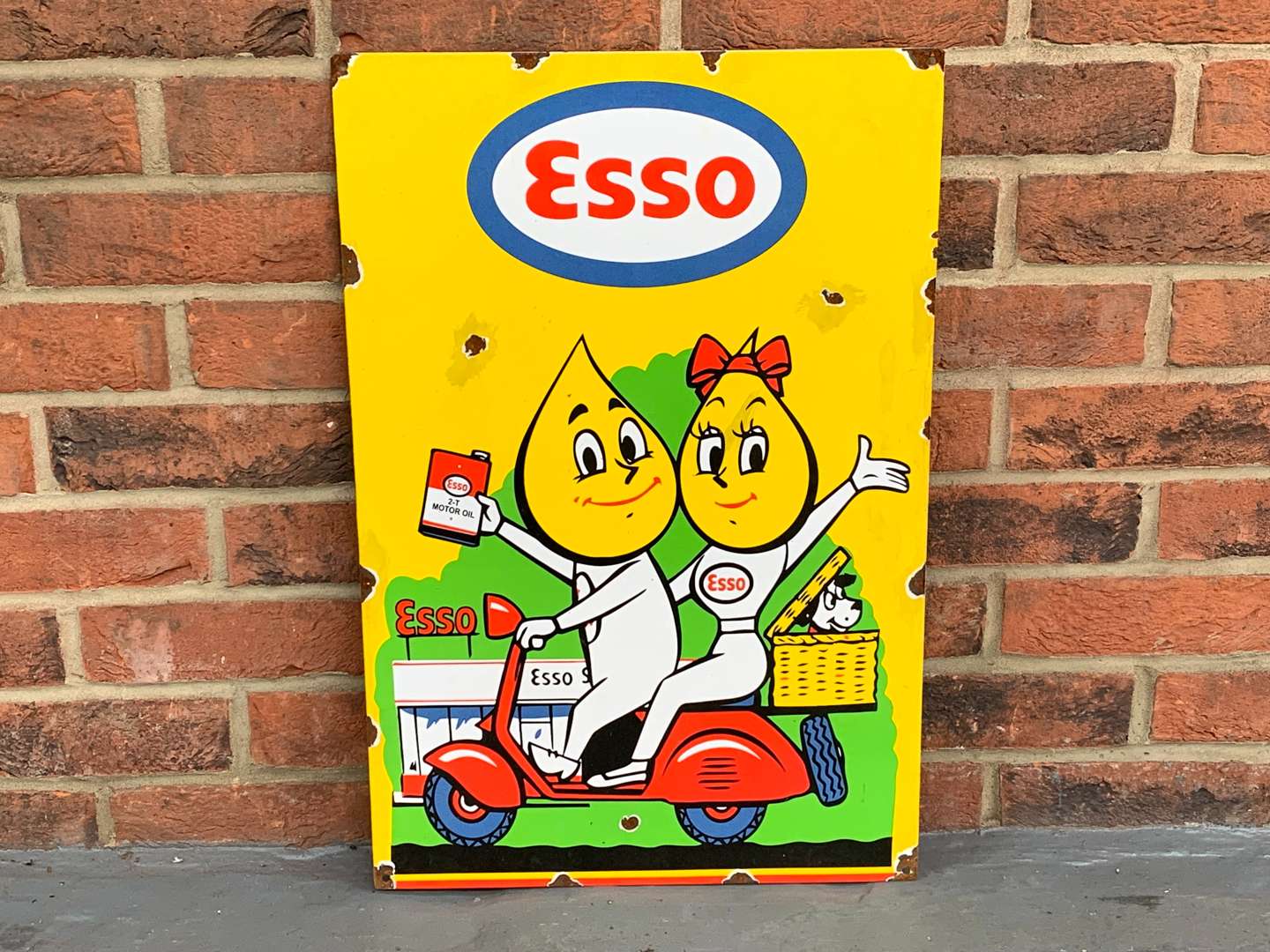 <p>Enamel Esso Mr and Mrs Drip on a Scooter Sign</p>