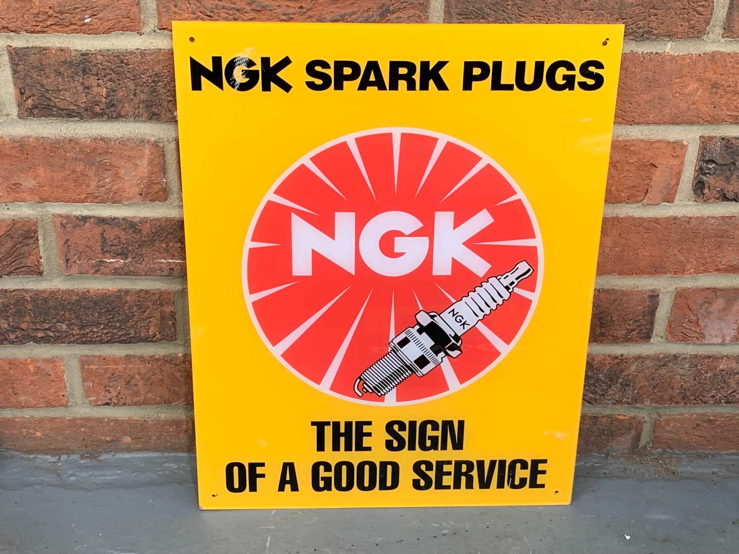 <p>Plastic NGK Spark Plug “The Sign of a Good Service” Sign</p>