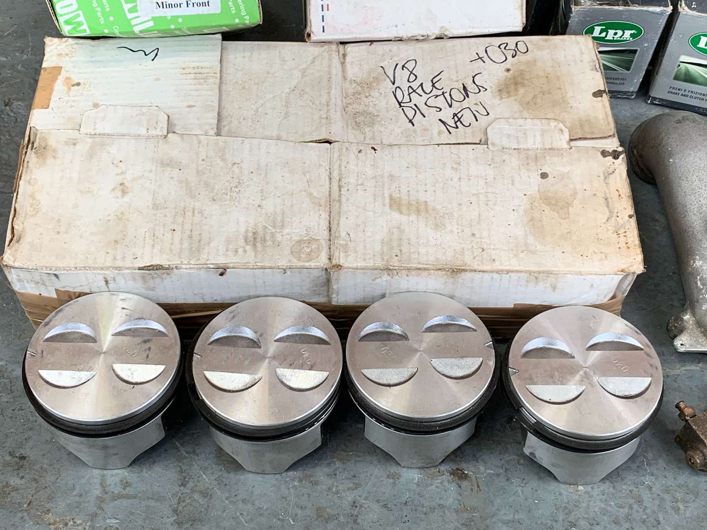 <p>Box of NOS V8 Race Pistons Corvair Light Lenses Etc</p>