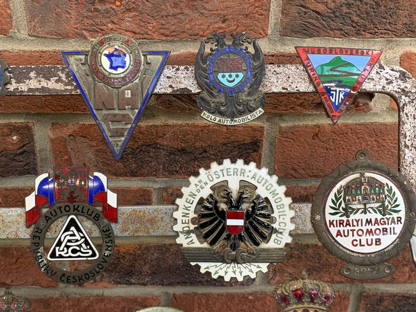 <p>A Significant Collection of Pre-War Badges on a Bar</p>