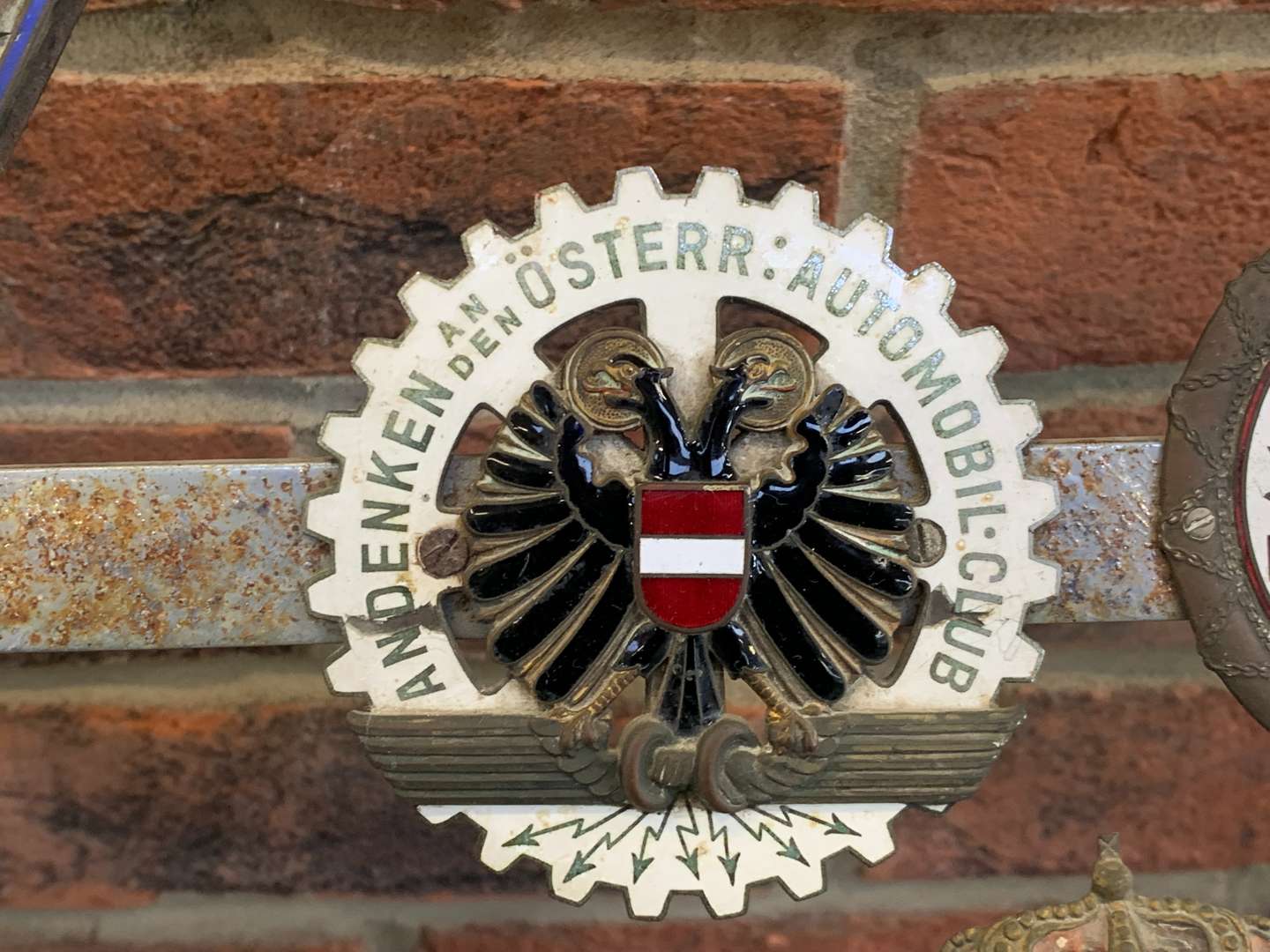 <p>A Significant Collection of Pre-War Badges on a Bar</p>