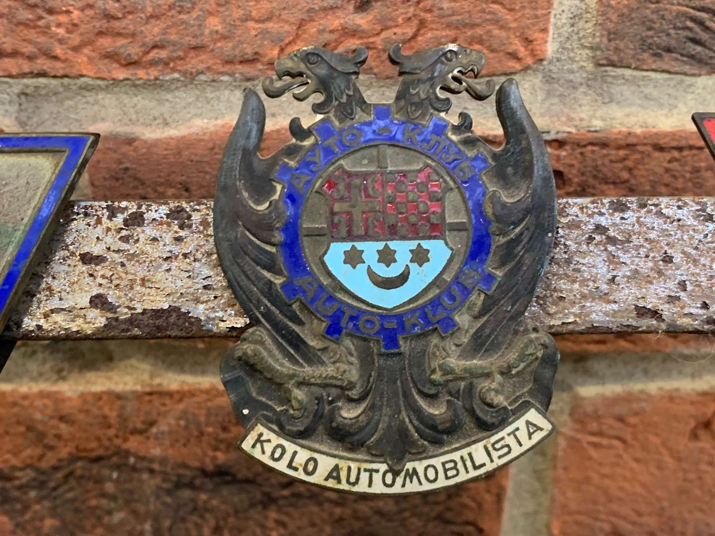 <p>A Significant Collection of Pre-War Badges on a Bar</p>