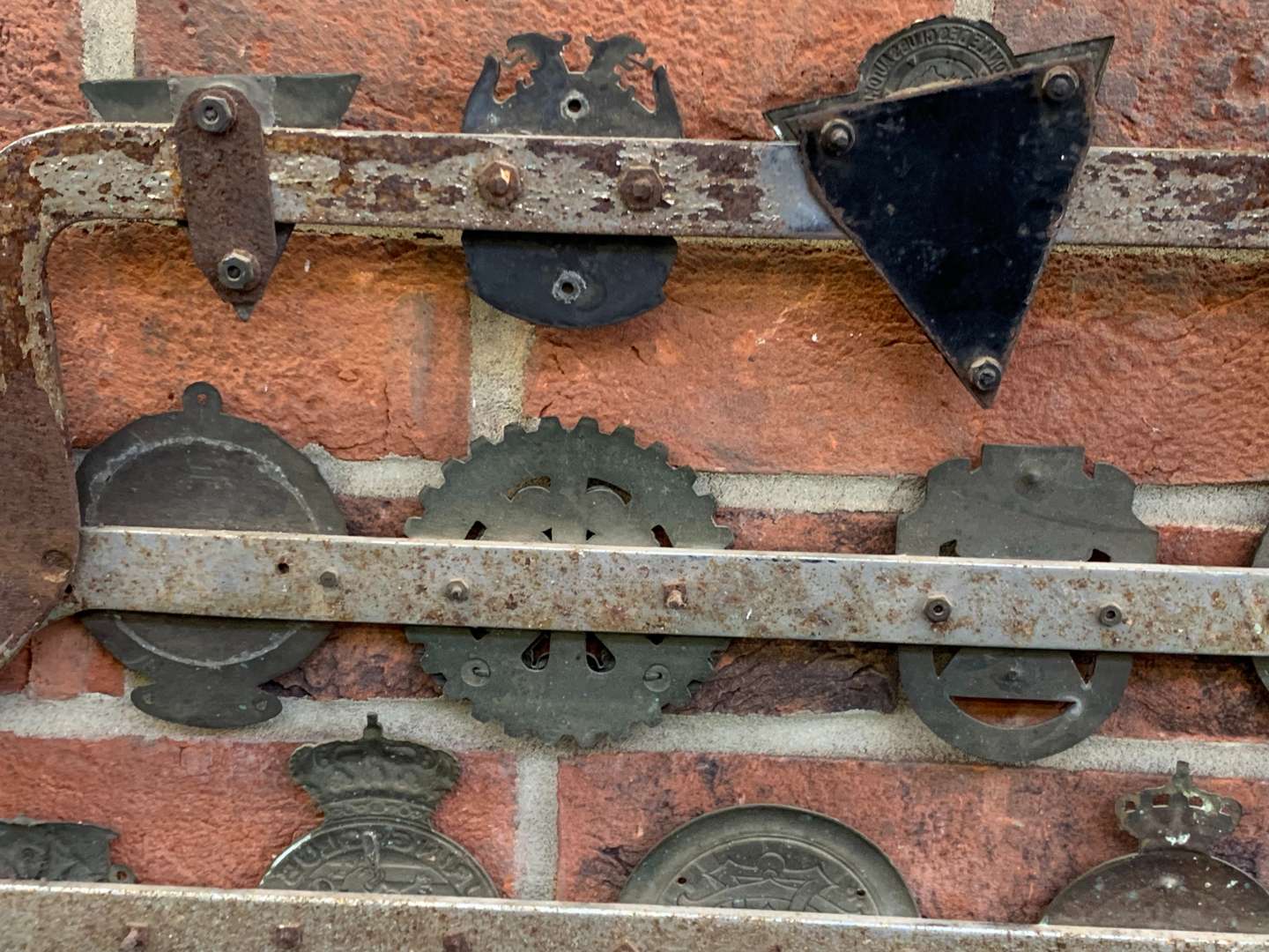 <p>A Significant Collection of Pre-War Badges on a Bar</p>