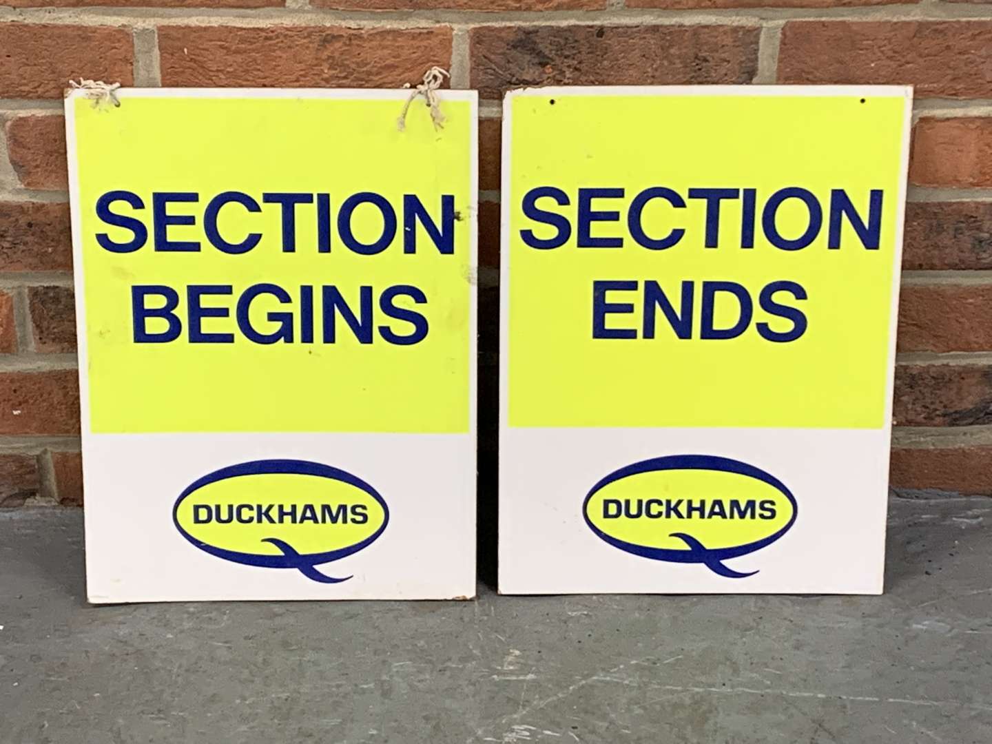 <p>Pair of Duckhams Section Begins/Ends Signs on Board</p>