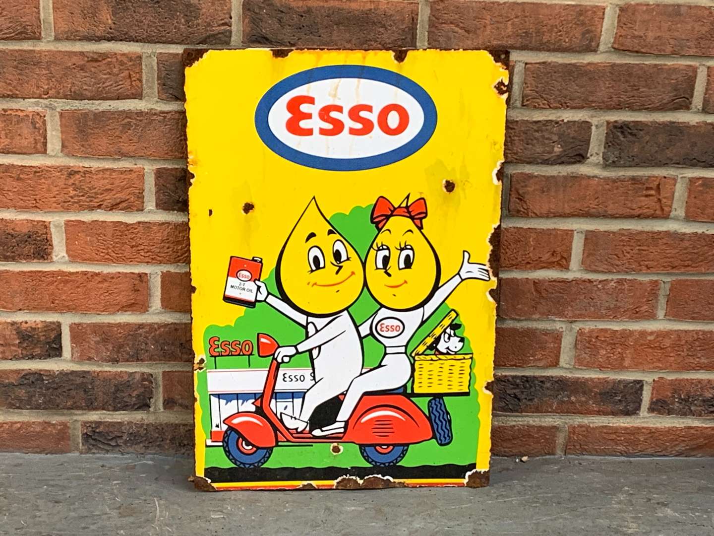 <p>Esso Mr and Mrs Drip on a Scooter Enamel Sign</p>