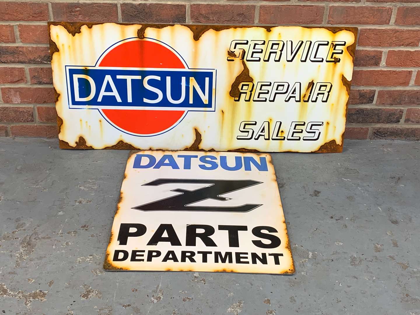 <p>Two Metal Datsun Signs</p>