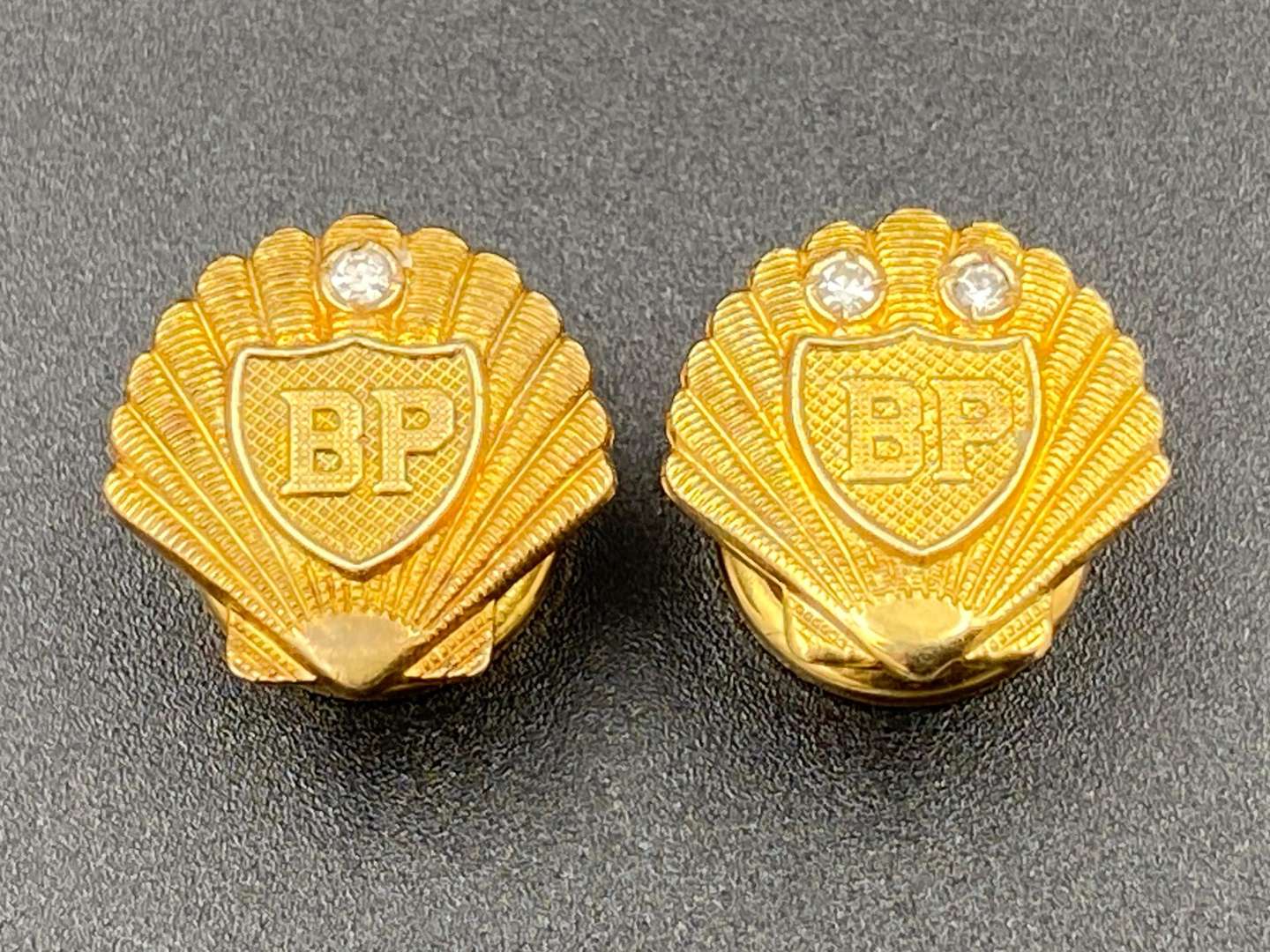 <p>SHELL-MEX & BP LTD, two 1950's 9ct gold and diamond set “Long Service” lapel badges, &nbsp;</p>