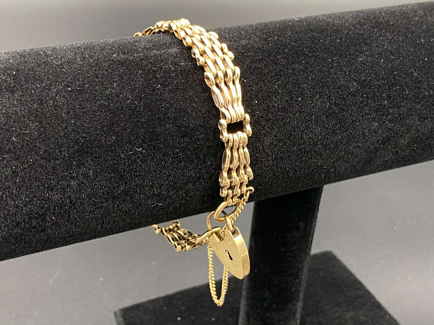 <p>A 9ct gold graduated gate link bracelet with heart shaped padlock clasp</p>