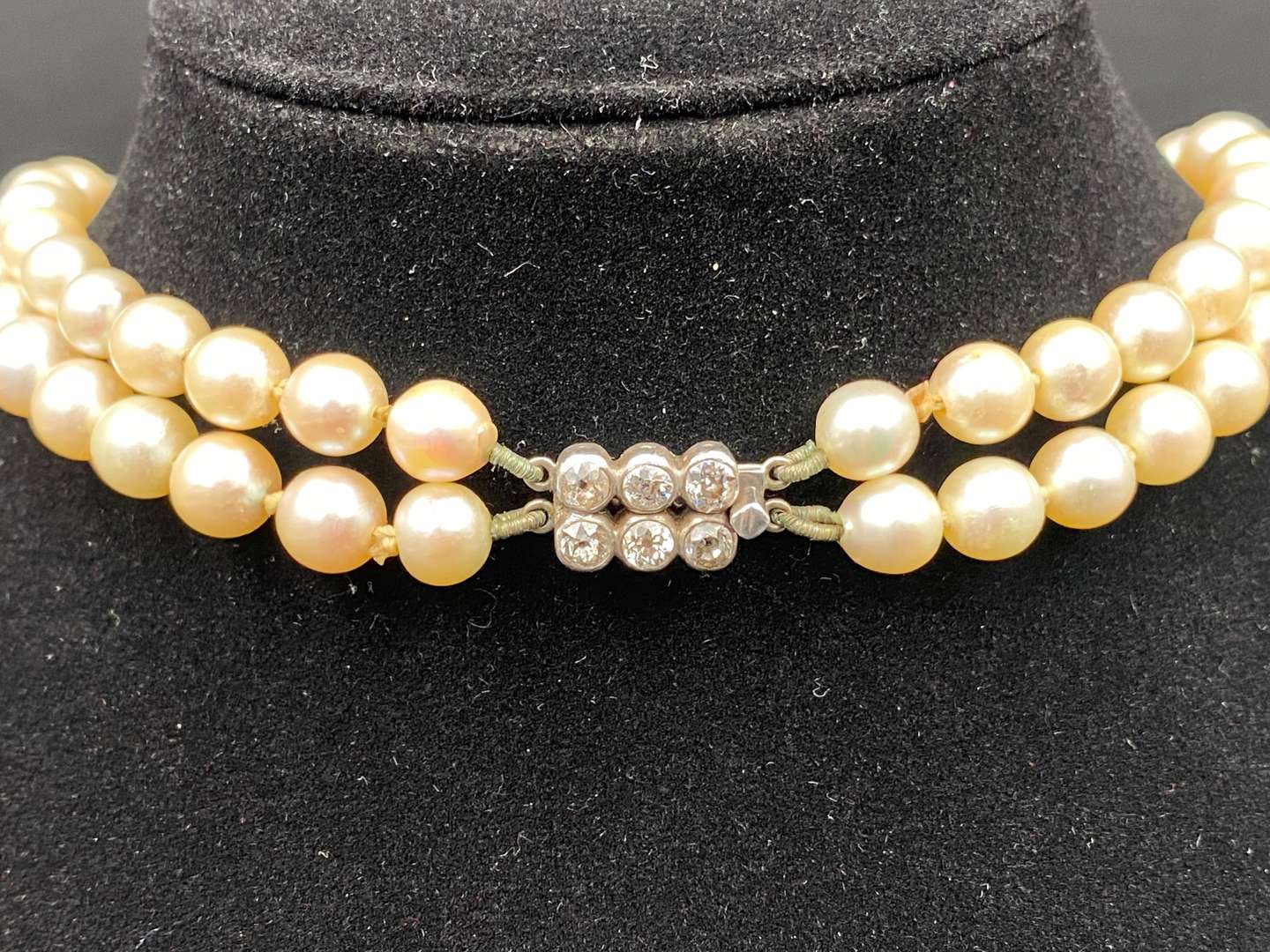 <p>Twin strand of graduated, cultured pearls, with diamond clasp set with six old cut stones.</p>