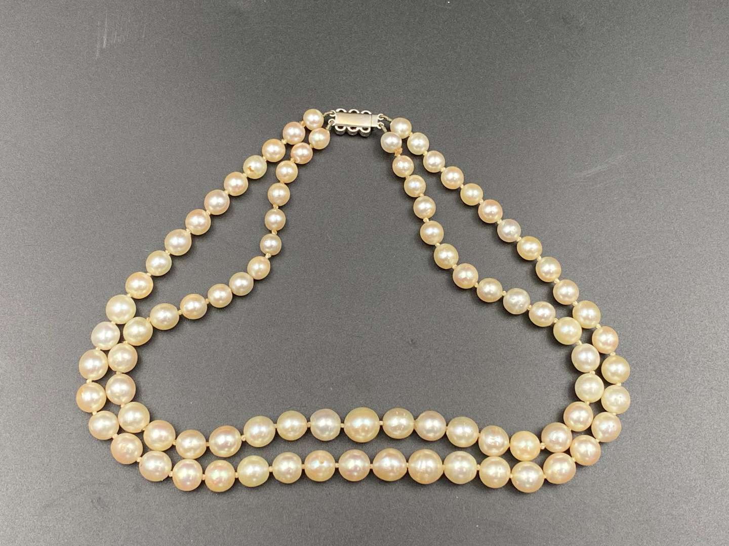 <p>Twin strand of graduated, cultured pearls, with diamond clasp set with six old cut stones.</p>