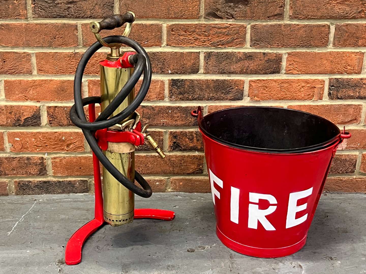 <p>Metal Fire Bucket and Brass Pump on Stand</p>