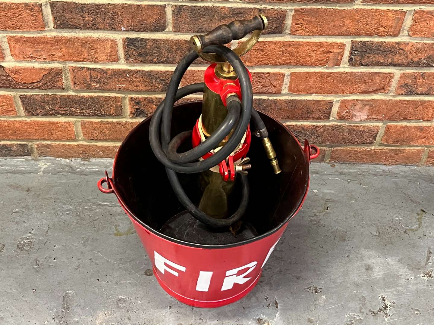 <p>Metal Fire Bucket and Brass Pump on Stand</p>