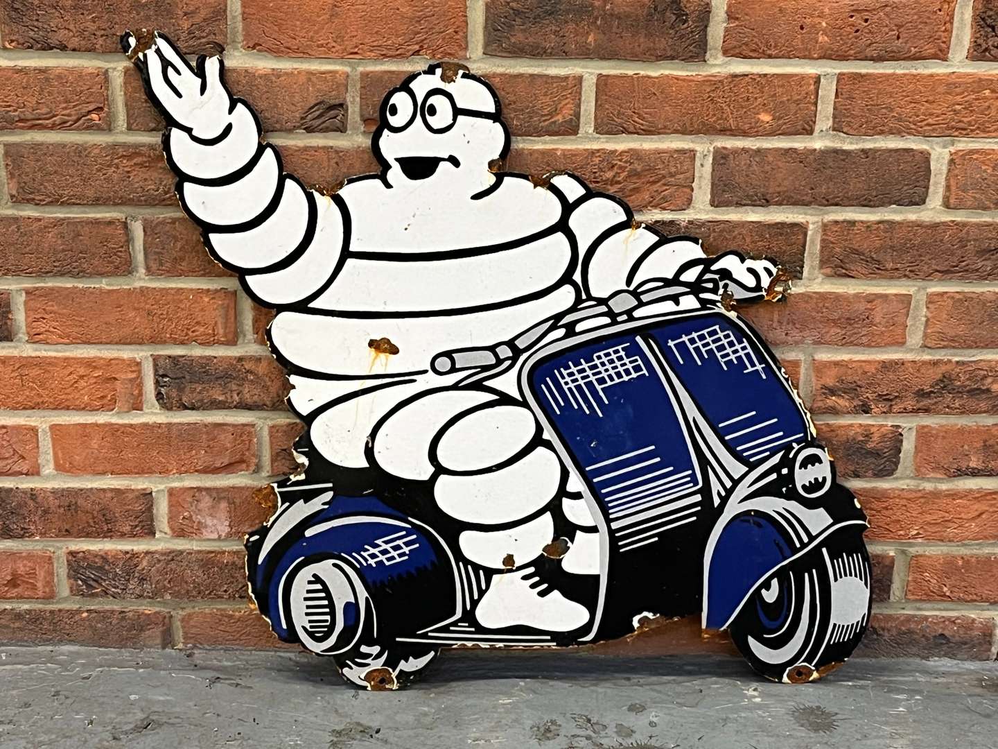 <p>Michelin Man on a Scooter Enamel Sign</p>