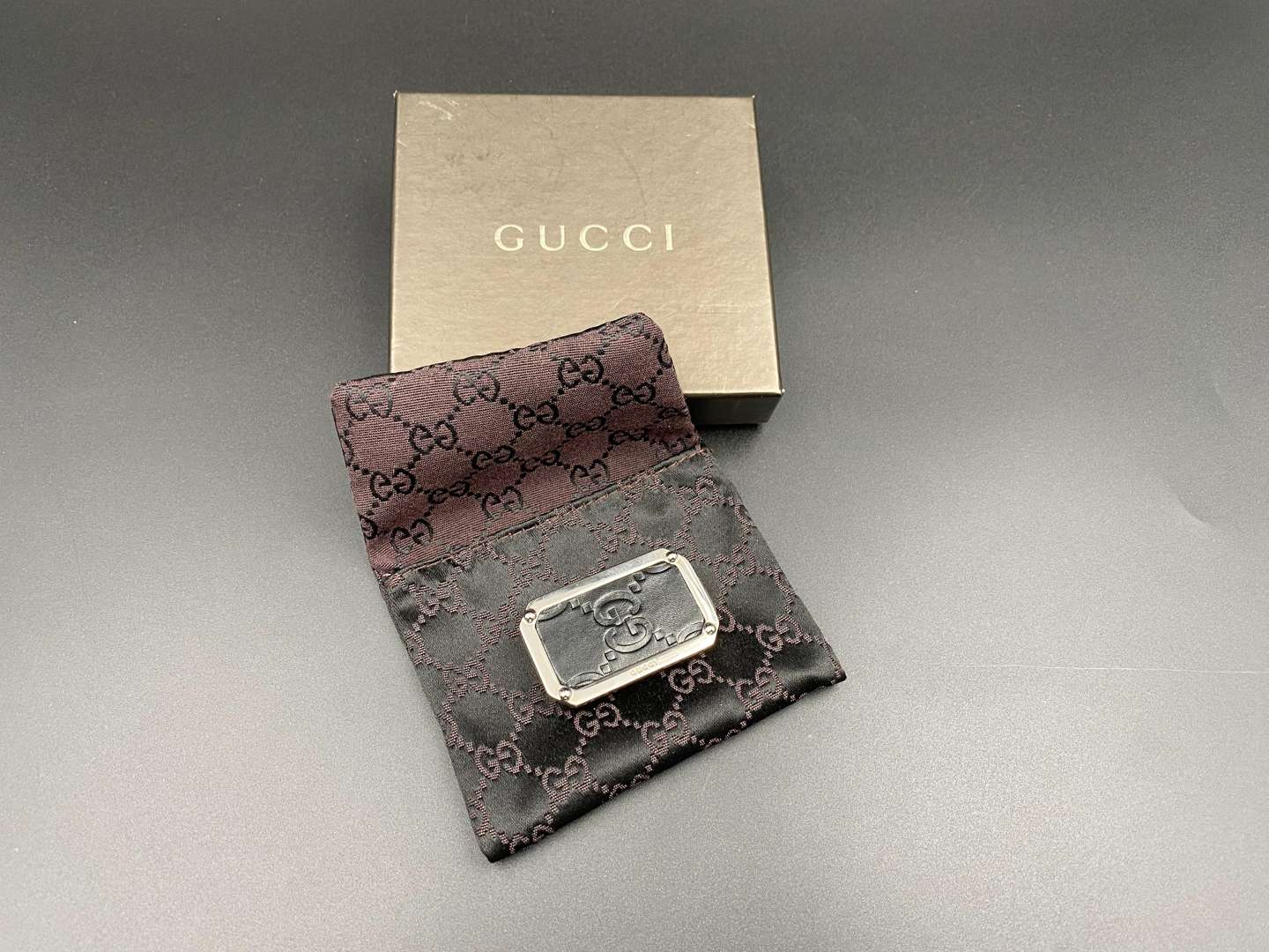 <p>GUCCI, polished stainless steel and monogrammed leather inset money clip,</p>