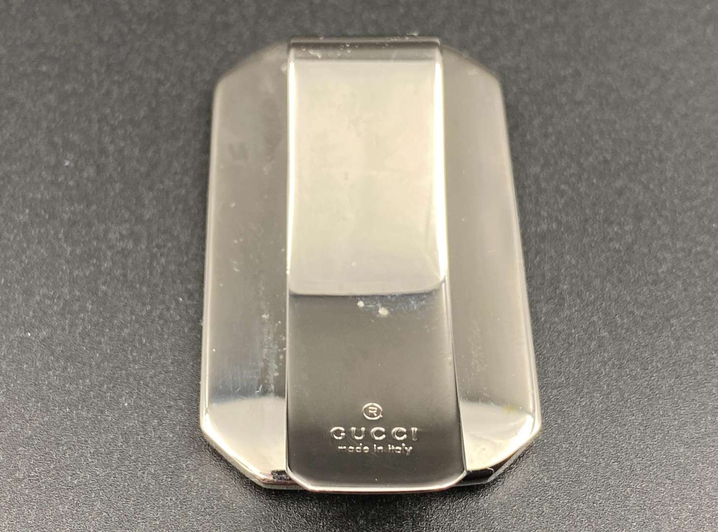 <p>GUCCI, polished stainless steel and monogrammed leather inset money clip,</p>
