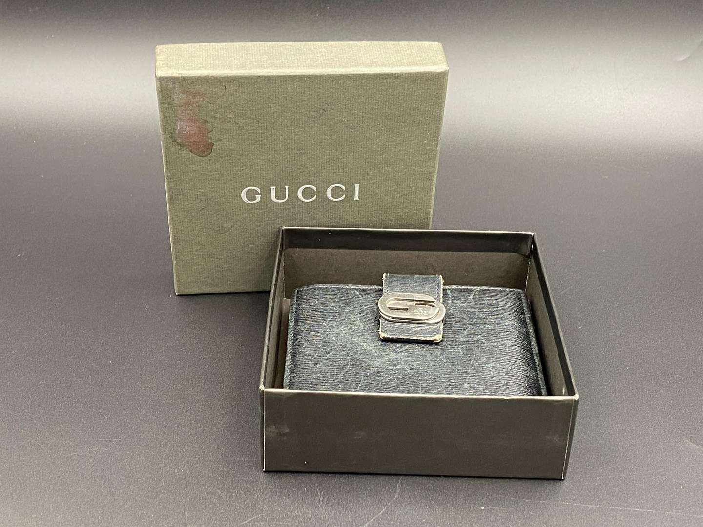 <p>GUCCI, &nbsp;a black, grained, leather wallet with signed and polished clasp</p>