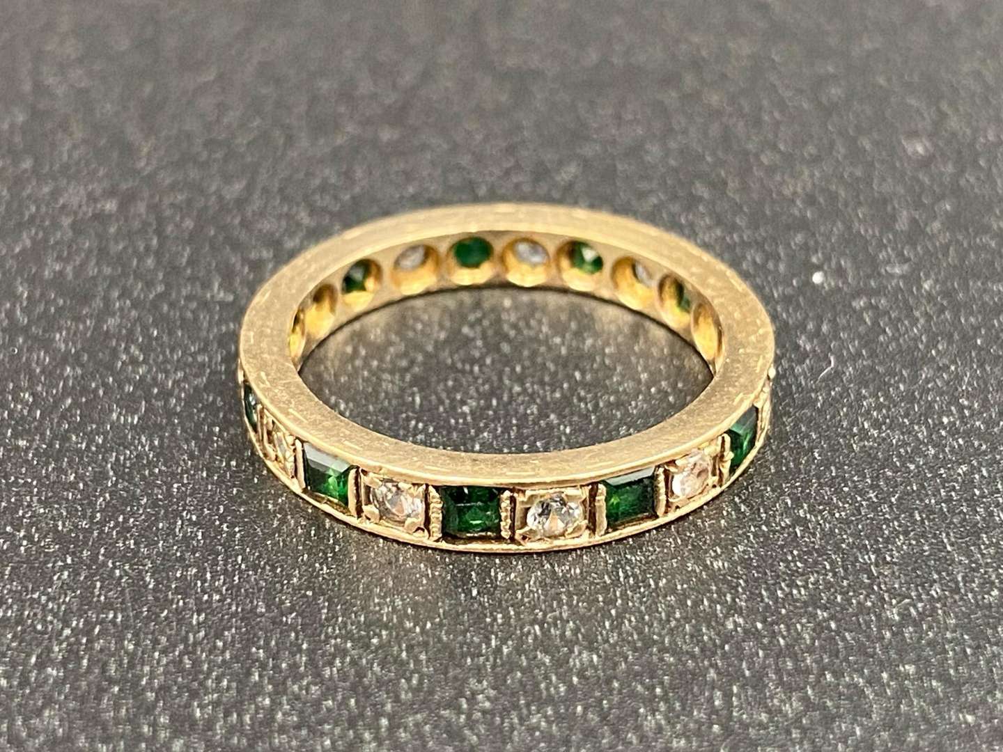 <p>A green and white paste set, 9ct gold, Eternity ring,</p>