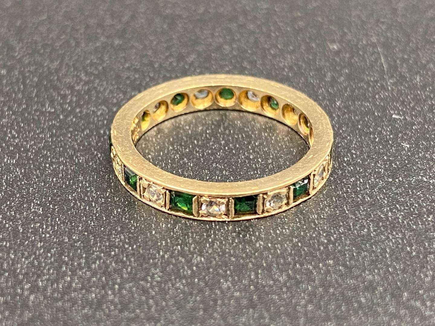 <p>A green and white paste set, 9ct gold, Eternity ring,</p>