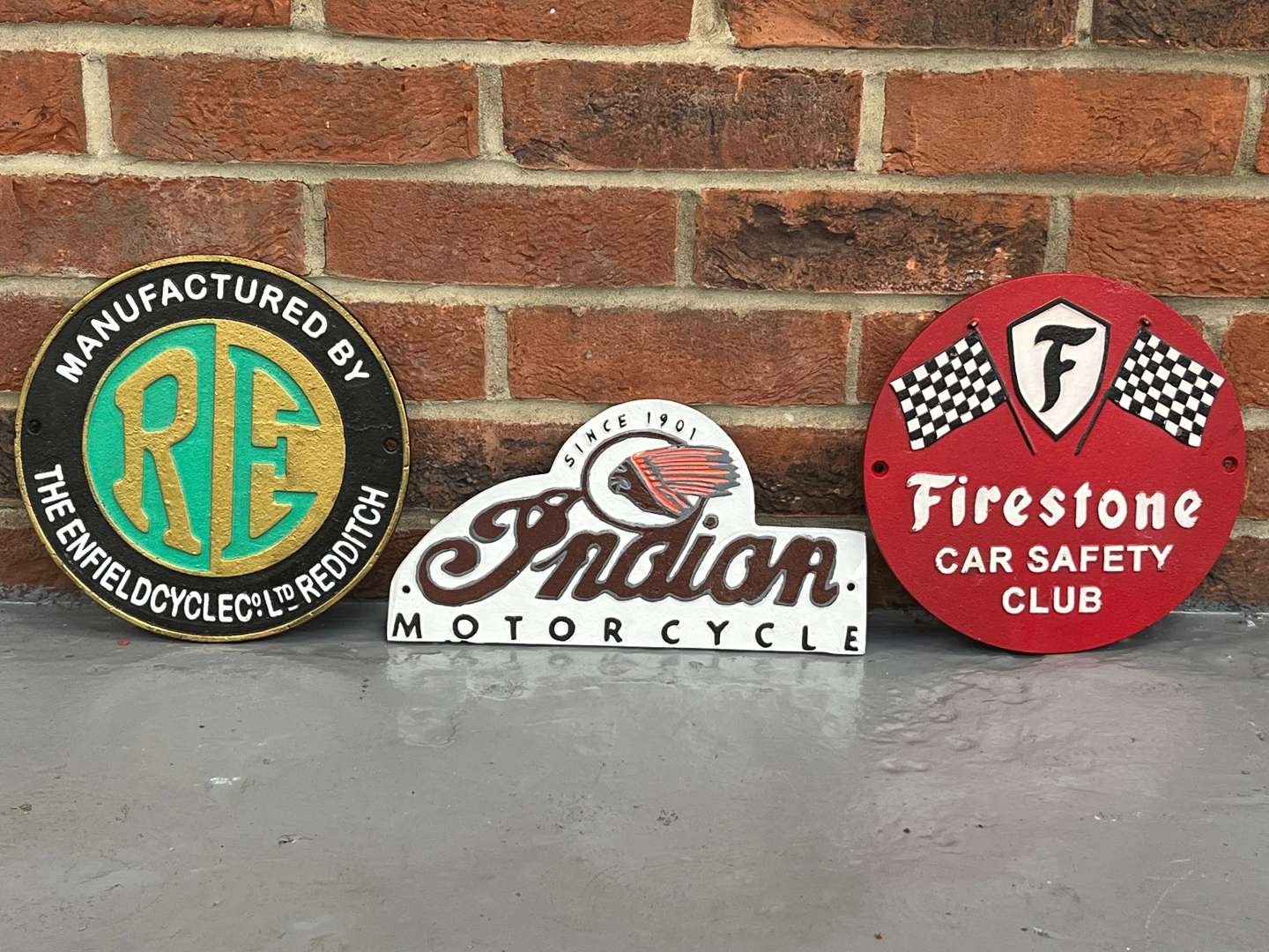 <p>Three Cast Iron Royal Enfield, Indian and Firestone Tires Signs</p>