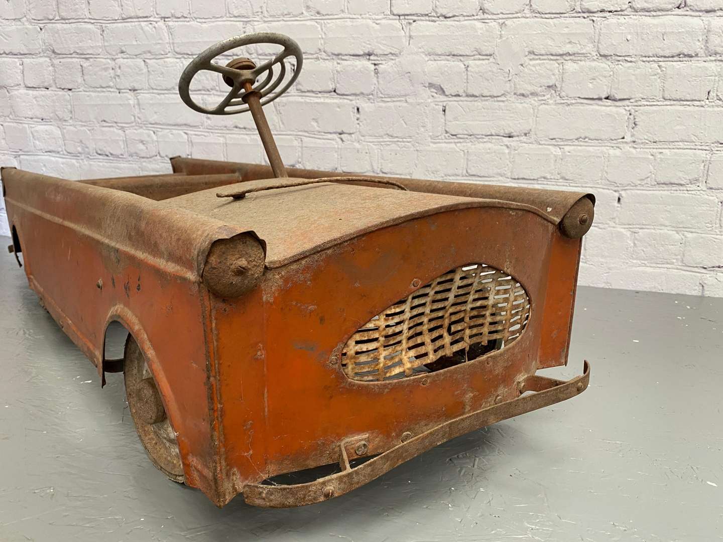 <p>A mid 20th century pressed steel pedal car,</p>