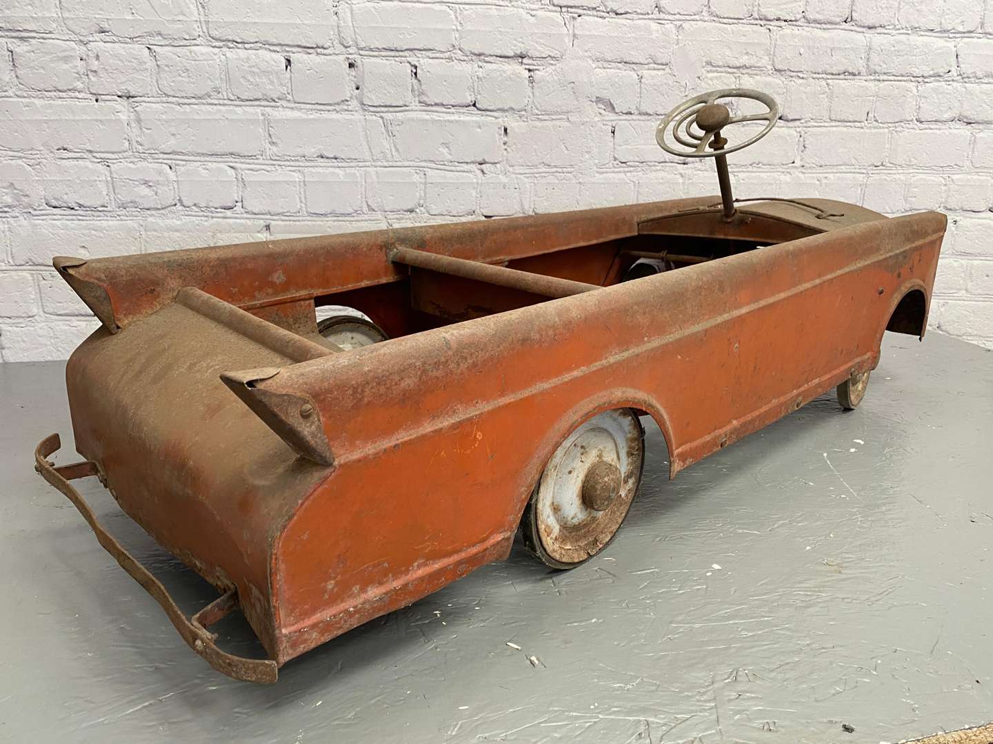 <p>A mid 20th century pressed steel pedal car,</p>