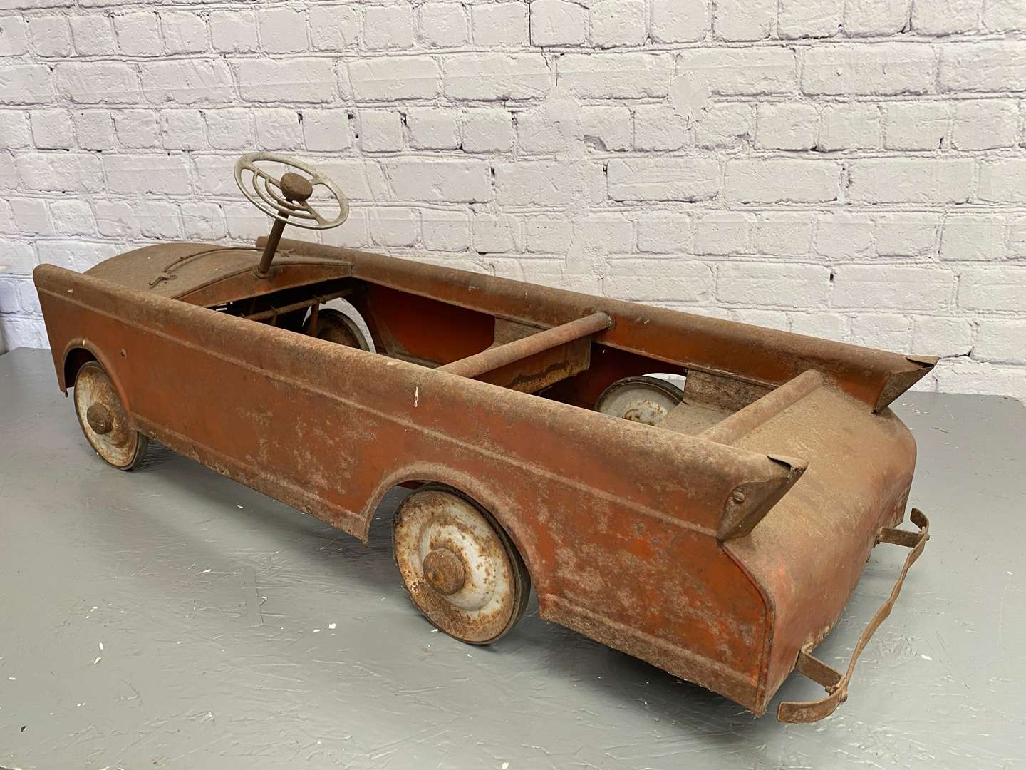 <p>A mid 20th century pressed steel pedal car,</p>