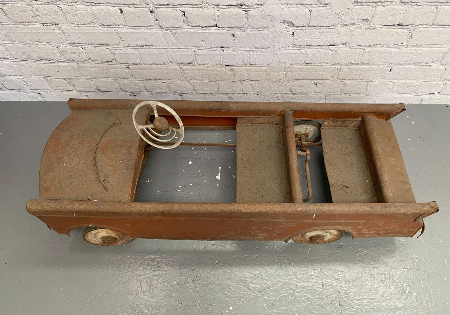 <p>A mid 20th century pressed steel pedal car,</p>