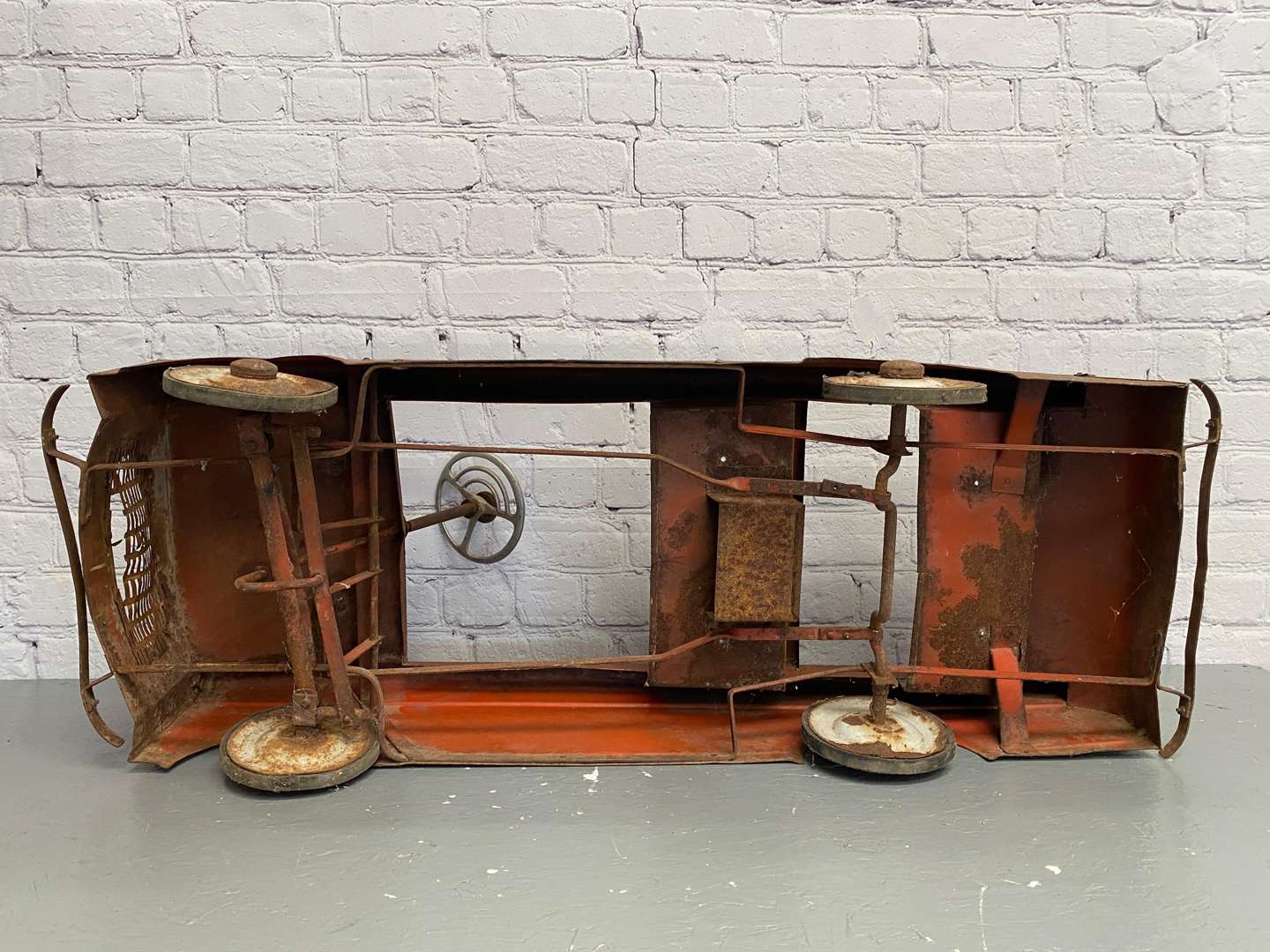 <p>A mid 20th century pressed steel pedal car,</p>