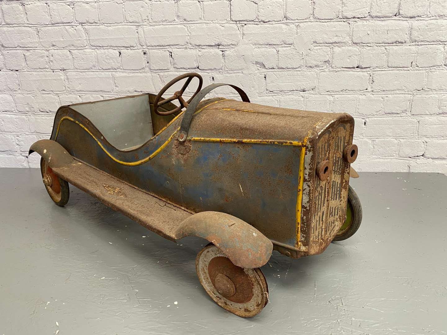 <p>A 1930s/40s pressed steel pedal car,</p>