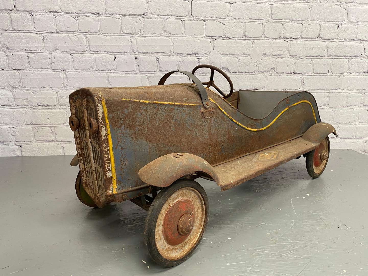 <p>A 1930s/40s pressed steel pedal car,</p>