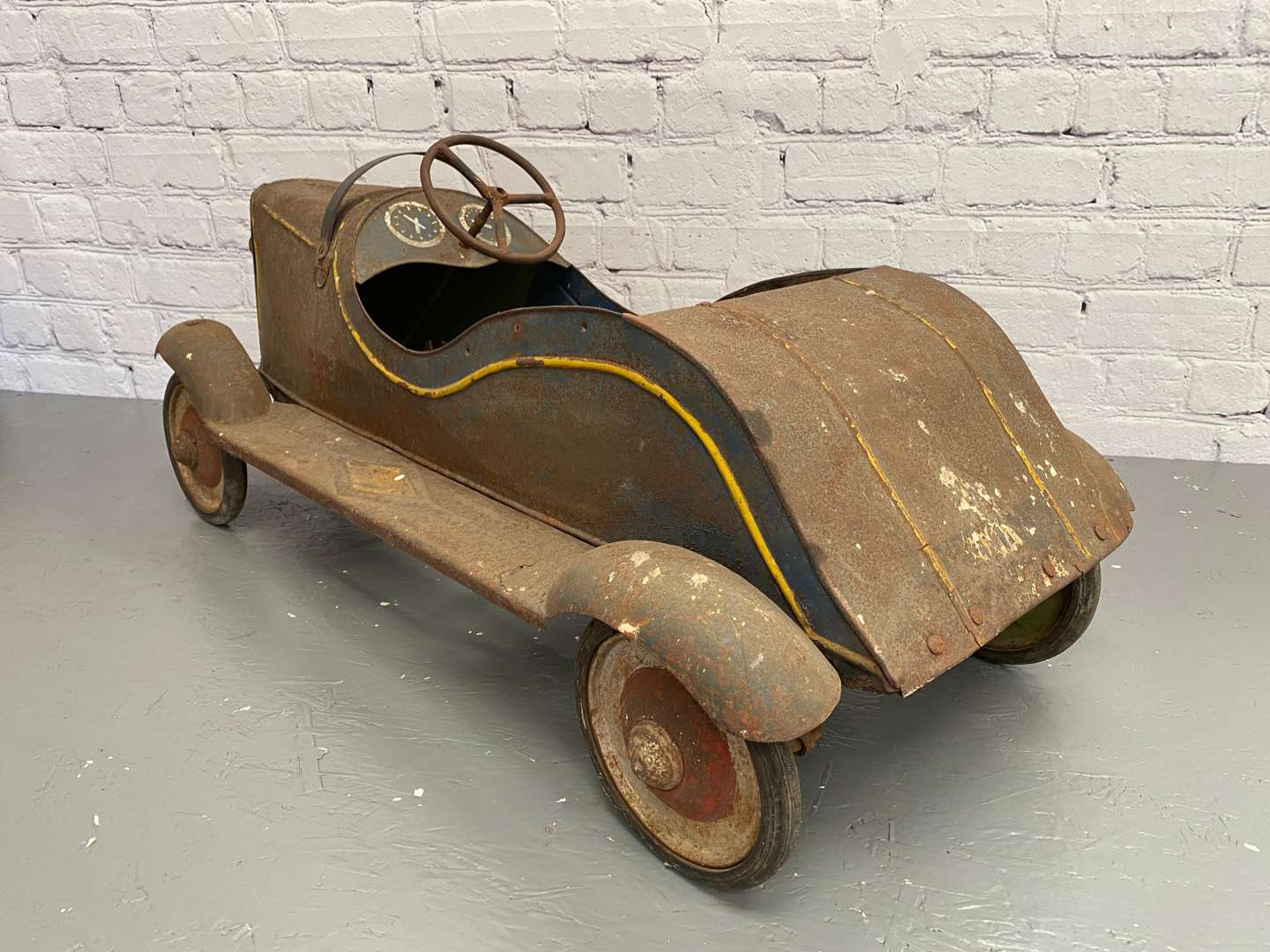 <p>A 1930s/40s pressed steel pedal car,</p>