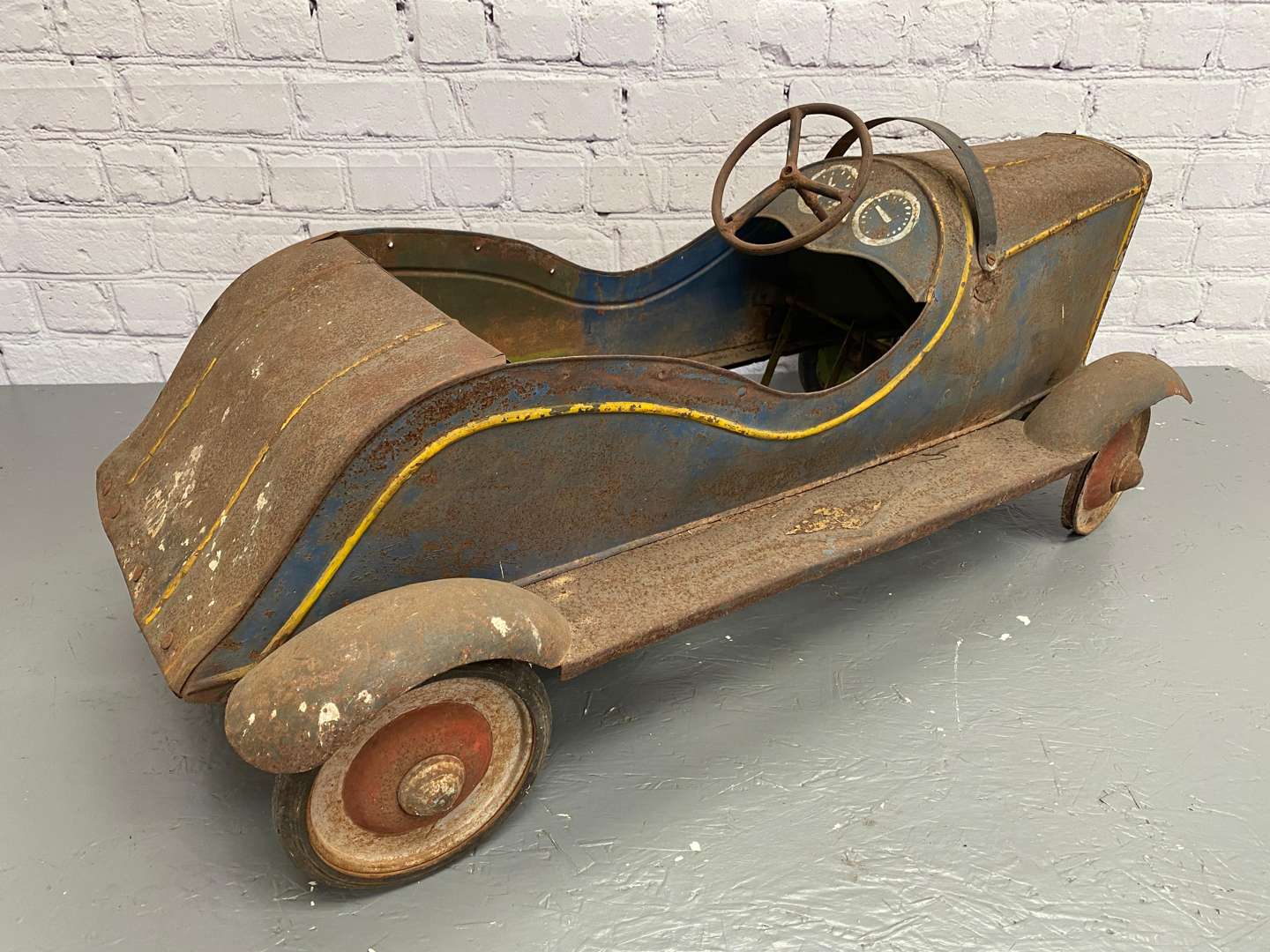 <p>A 1930s/40s pressed steel pedal car,</p>