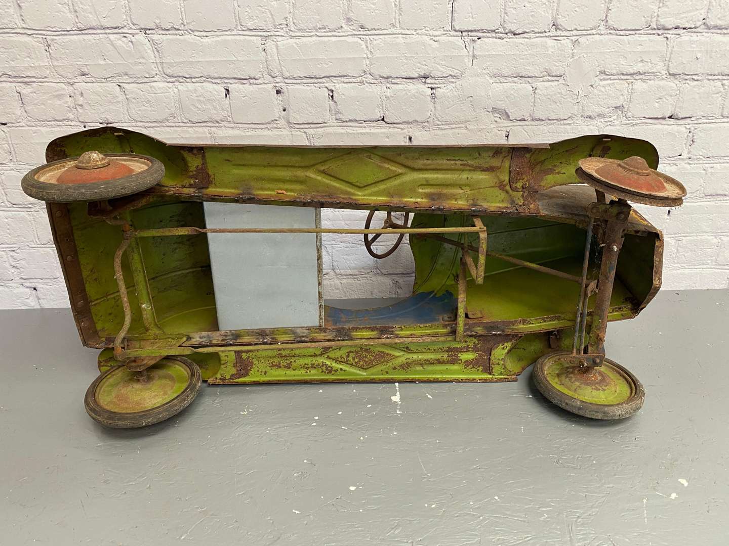 <p>A 1930s/40s pressed steel pedal car,</p>