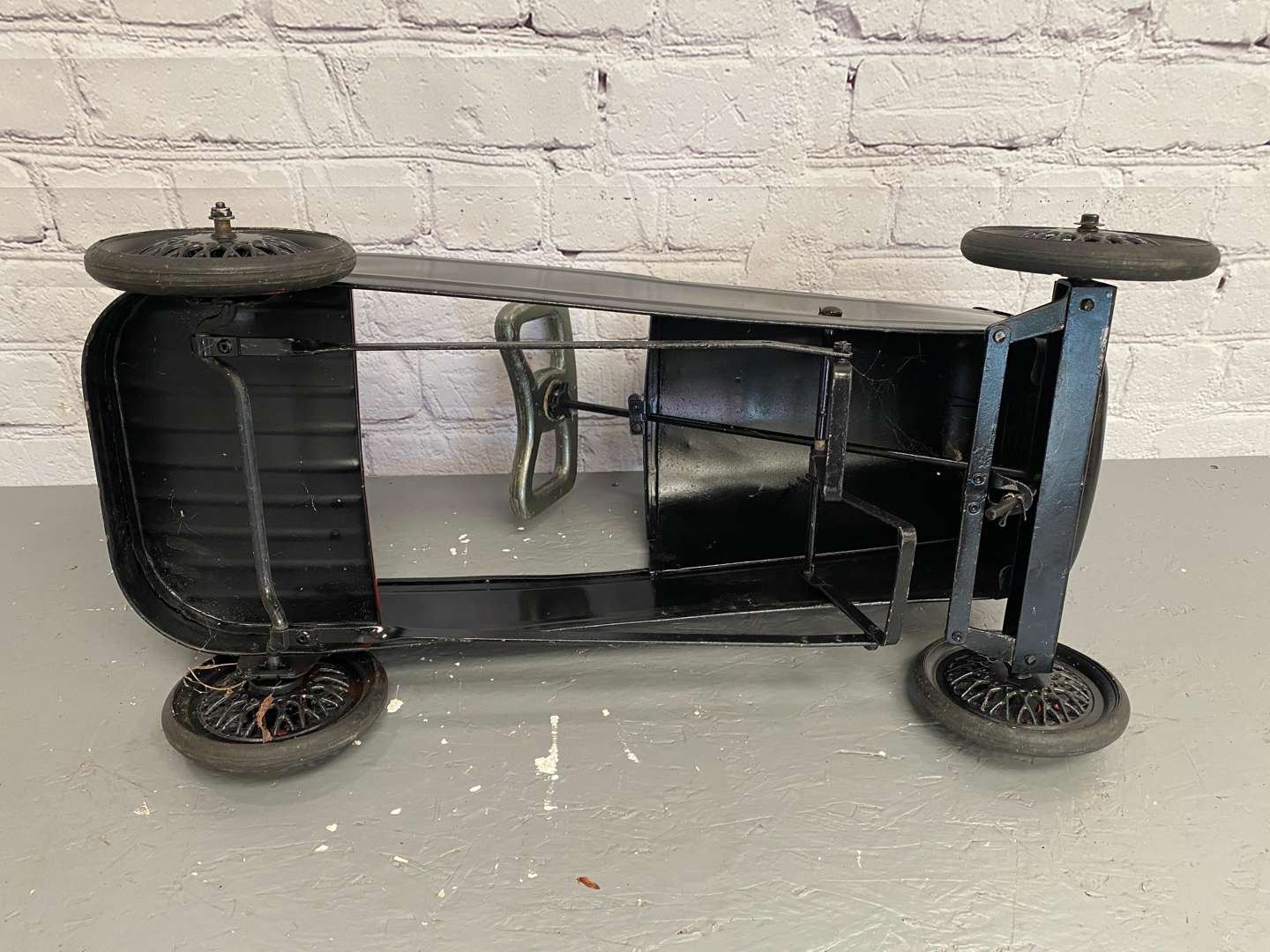 <p>A mid 20th century pressed steel pedal car,&nbsp;</p>