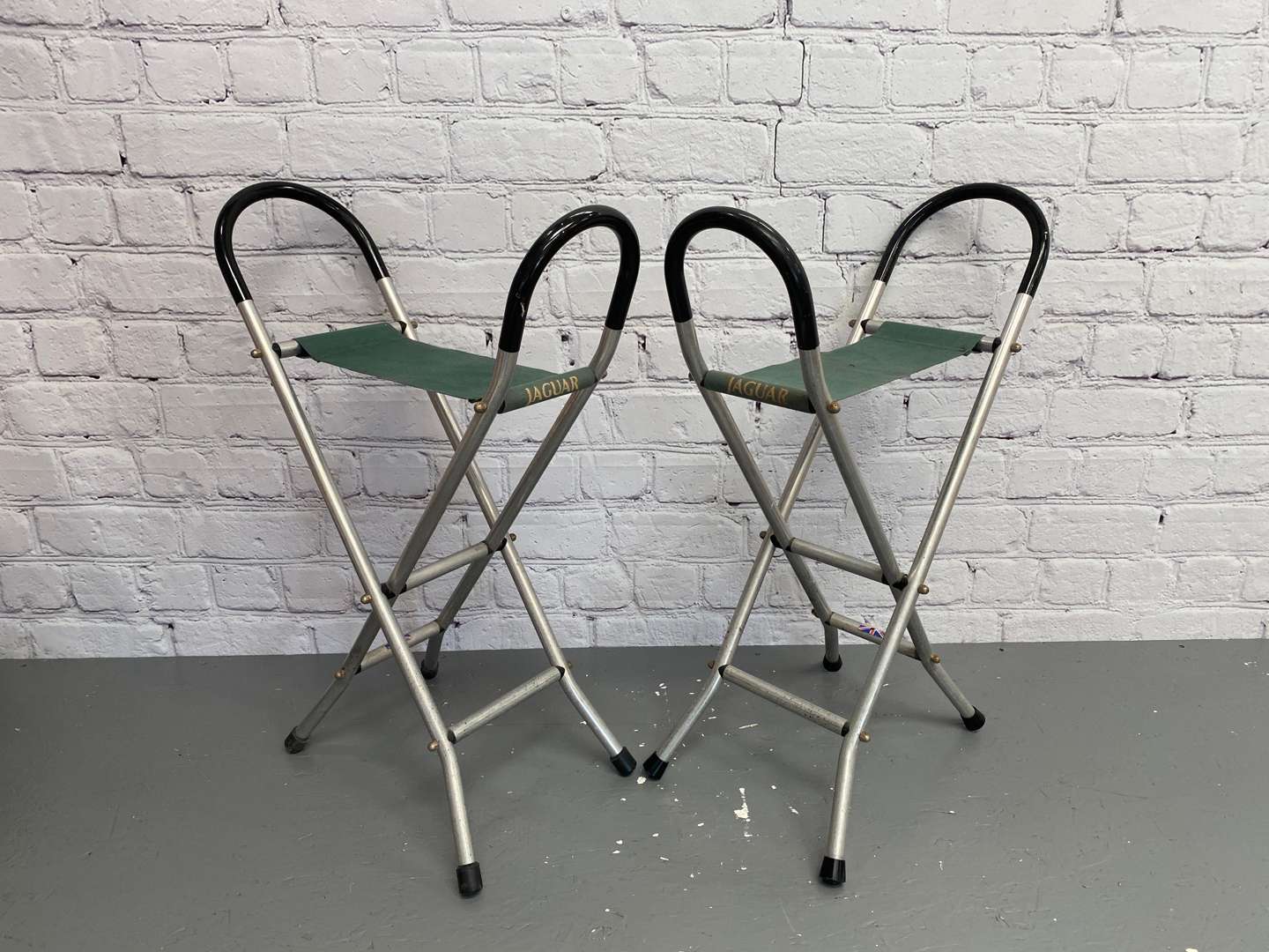 <p>Jaguar, a pair of late 20th century aluminium and canvas folding stools,&nbsp;</p>