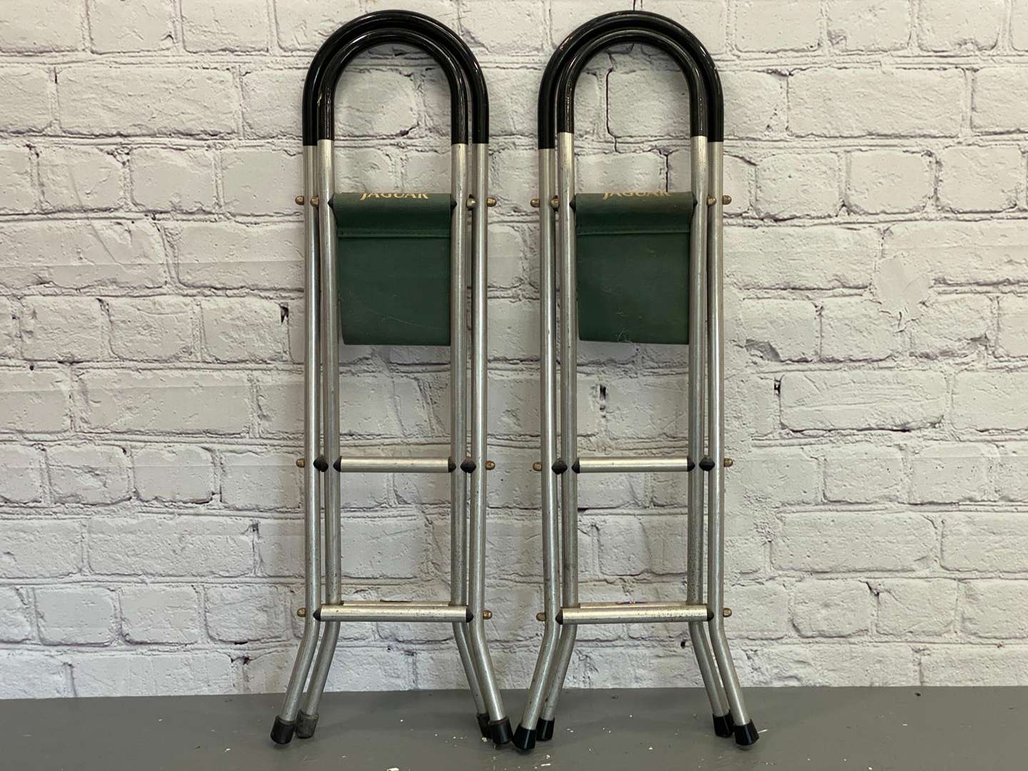 <p>Jaguar, a pair of late 20th century aluminium and canvas folding stools,&nbsp;</p>