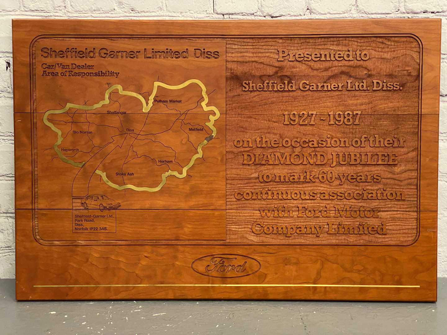 <p>Sheffield Garner Ltd- Diss, a modern carved wooden and brass inlaid presentation plaque,</p>
