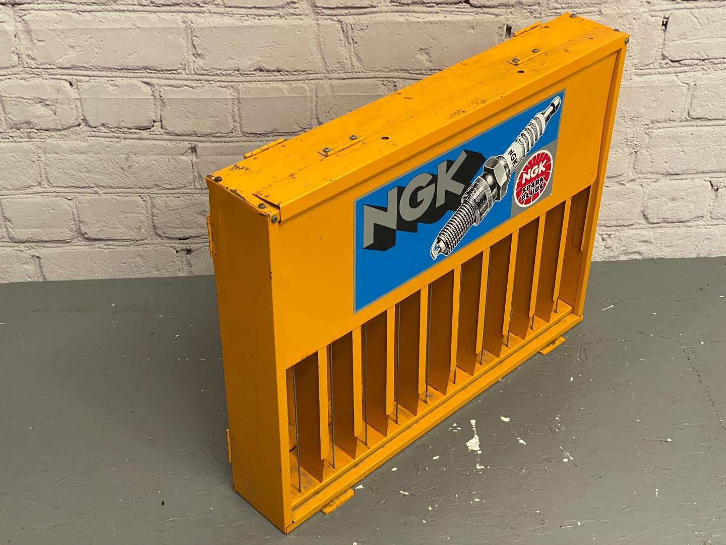 <p>NGK, a modern painted steel, wall mounted spark-plug dispenser,</p>