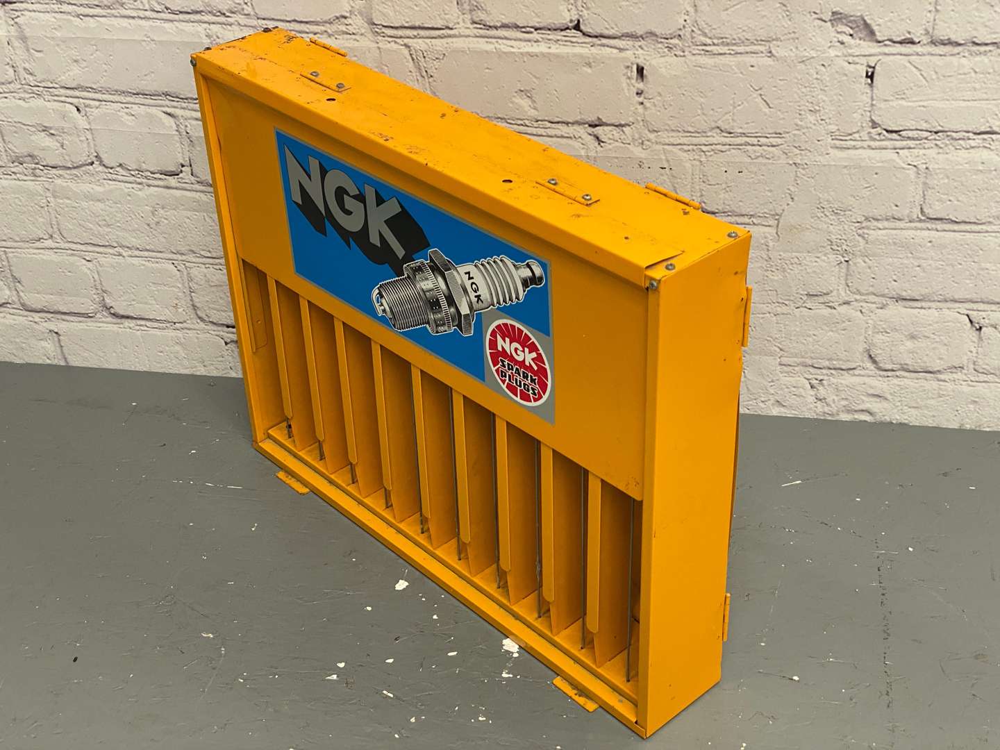 <p>NGK, a modern painted steel, wall mounted spark-plug dispenser,</p>