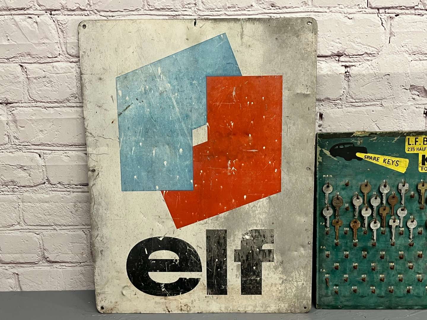 <p>Elf Oils Sign and LF Brenner Ltd Key Board</p>