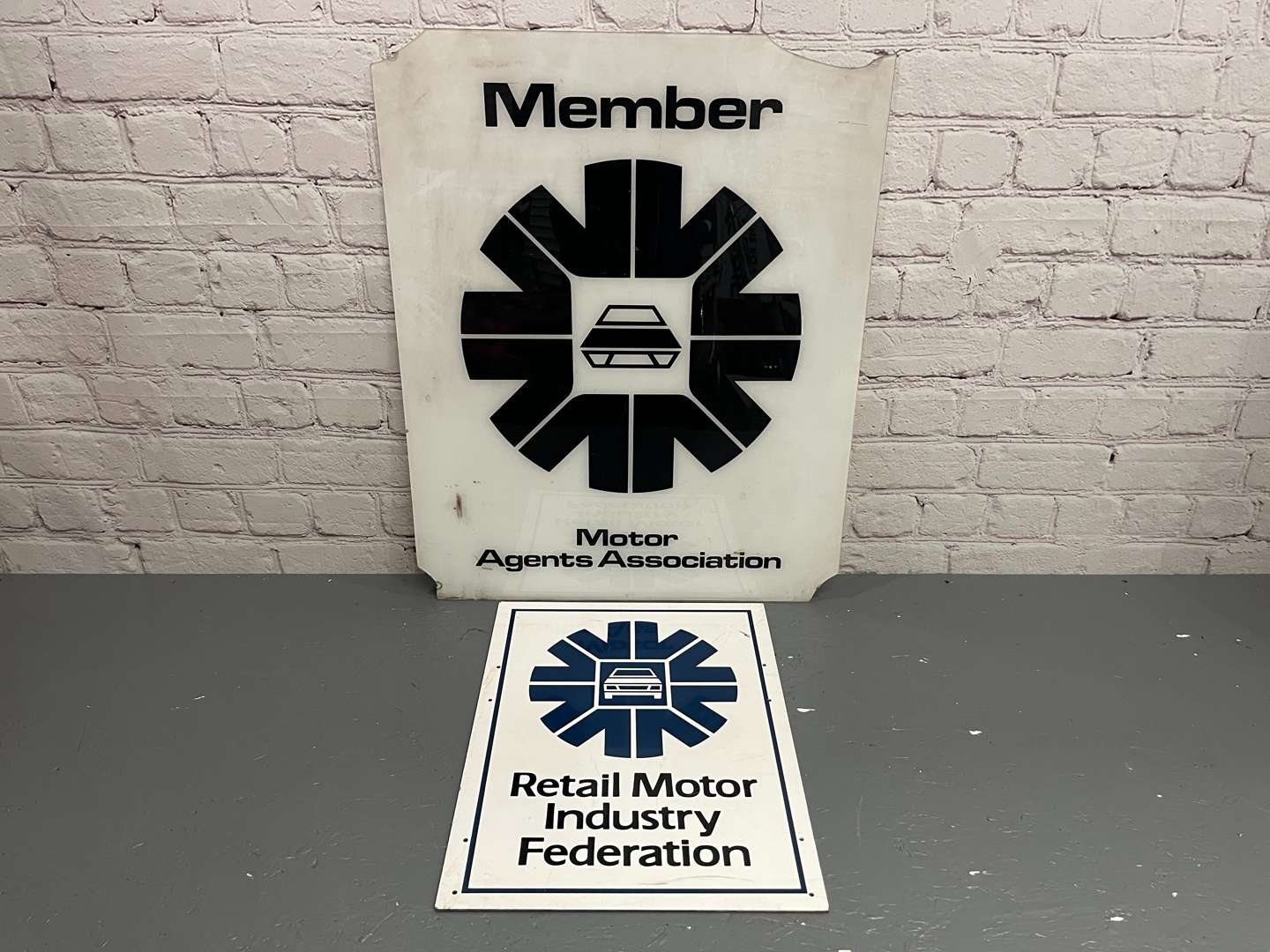 <p>Two Plastic Motor Agents Association Signs</p>